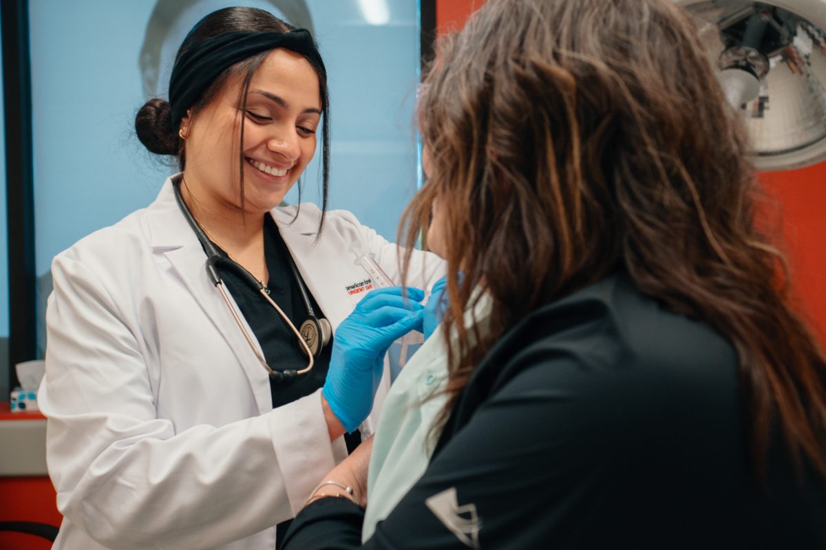 Smiling physician gives woman vaccinations for travel